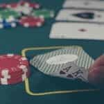 A poker table with two-hole cards and a stack of chips in the foreground.