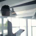 A businessman holding an iPad in an office.