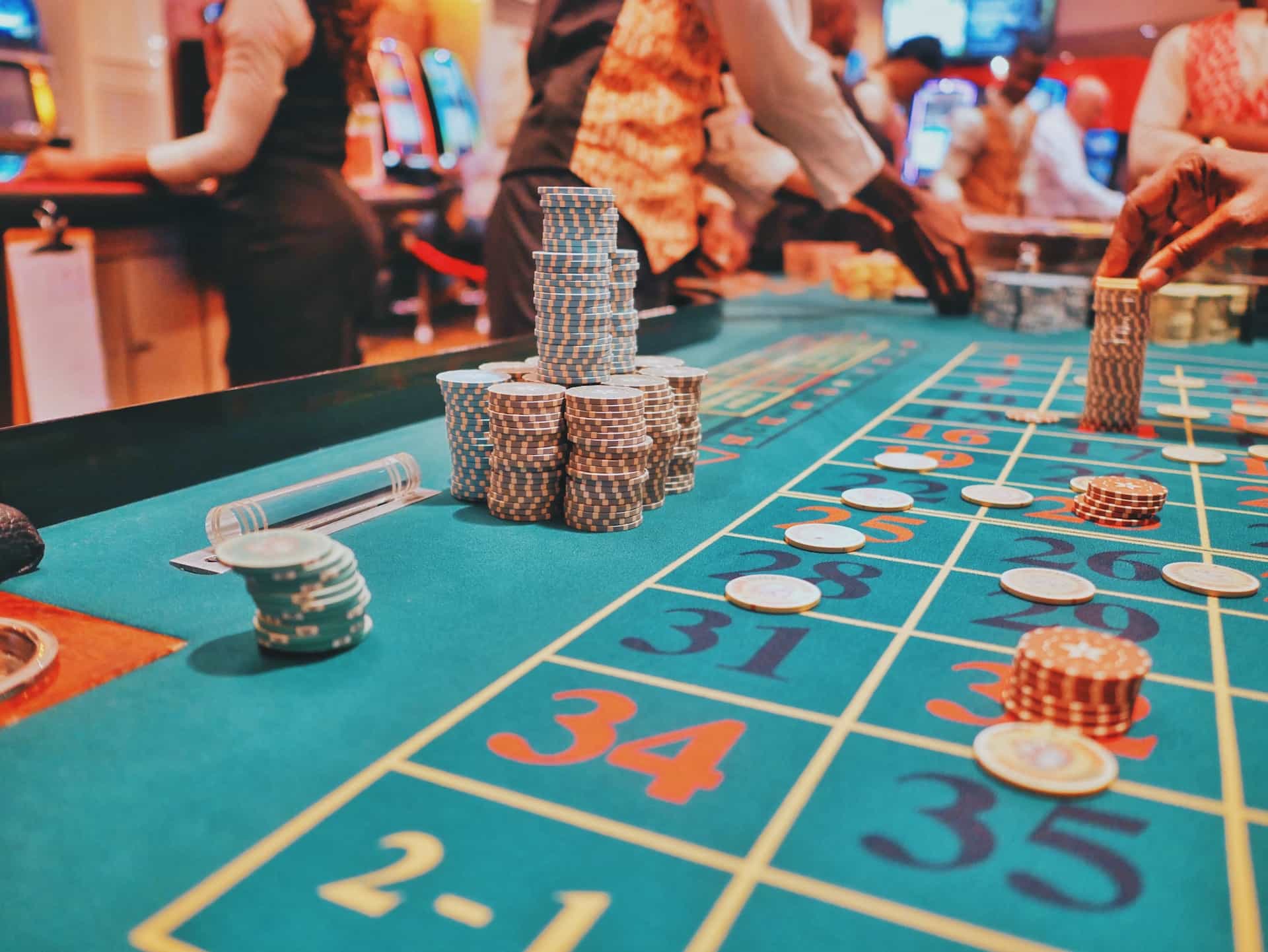 A table game at a physical retail casino location, featuring stacks of chips being set on various numbers by several dealers.