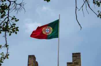 A flag hoisted on a building against the blue sky.