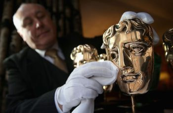 A BAFTA trophy gets a quick polish from an official.